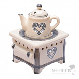 Aromalampe Teekanne aus Keramik auf dem Herd mit grauen Herzen
