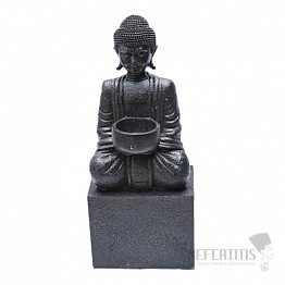 Buddha sitzt auf einem Sockel mit einer schwarzen Statuette mit Kerzenständer